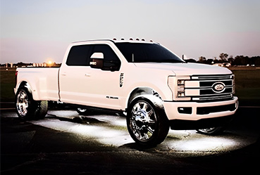 White off-road truck with Flashtech XL rock lights illuminating the ground at dusk